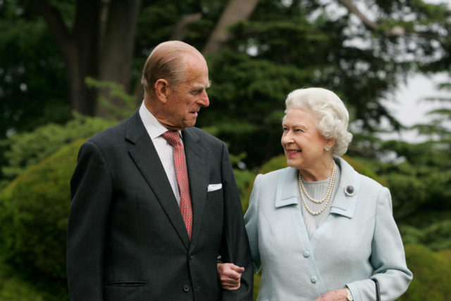 Prince Philip and Queen Elizabeth smile at each other during a portrait session outdoors