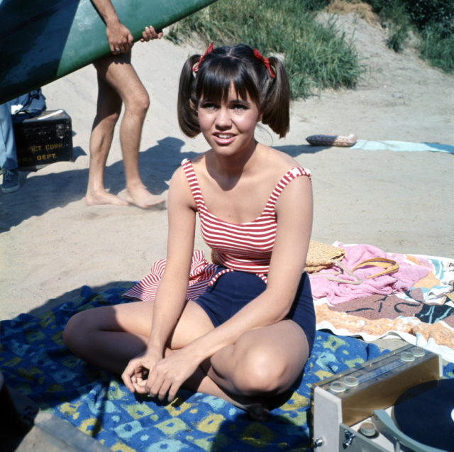 Sally Field sits on a beach while filming Gidget in 1966.