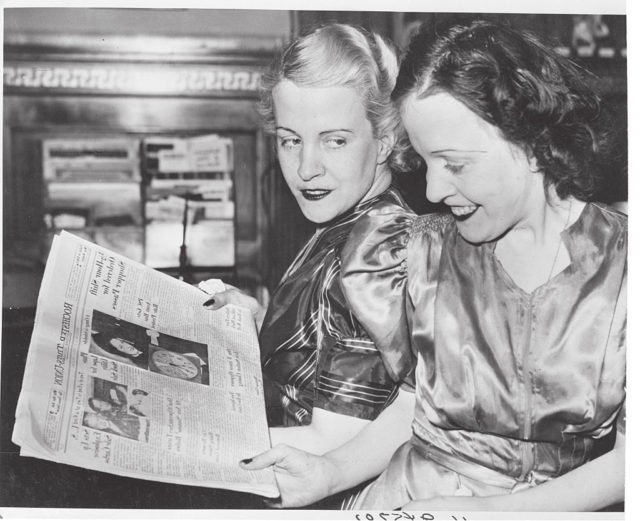 Daisy and Violet Hilton reading a newspaper