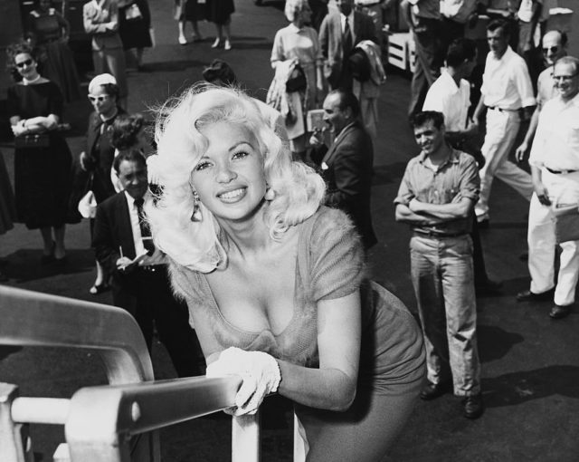 Jayne Mansfield leaning on a railing 
