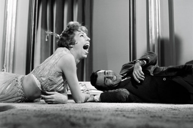 Carol Burnett and Rod Serling laugh while laying on the floor during filming for "The Twilight Zone".