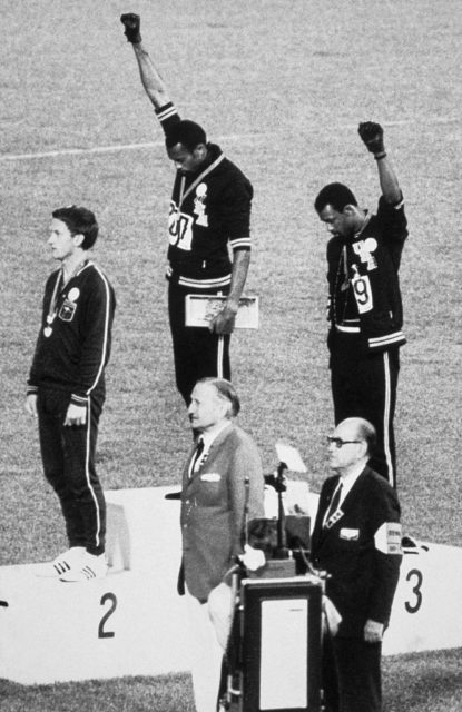 Tommie Smith and John Carlos raise their first and give a black power salute