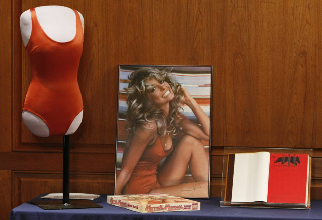 Photo of the Farrah Fawcett display at the Smithsonian National Museum of American History, showcasing the iconic red swimsuit, poster, and Charlie's Angels script