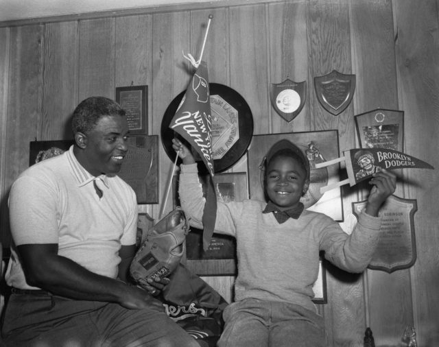Jackie Robinson and his son pose for photo in trophy room