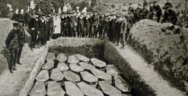 Photo of mourners surrounding grave with multiple coffins of victims of the Titanic