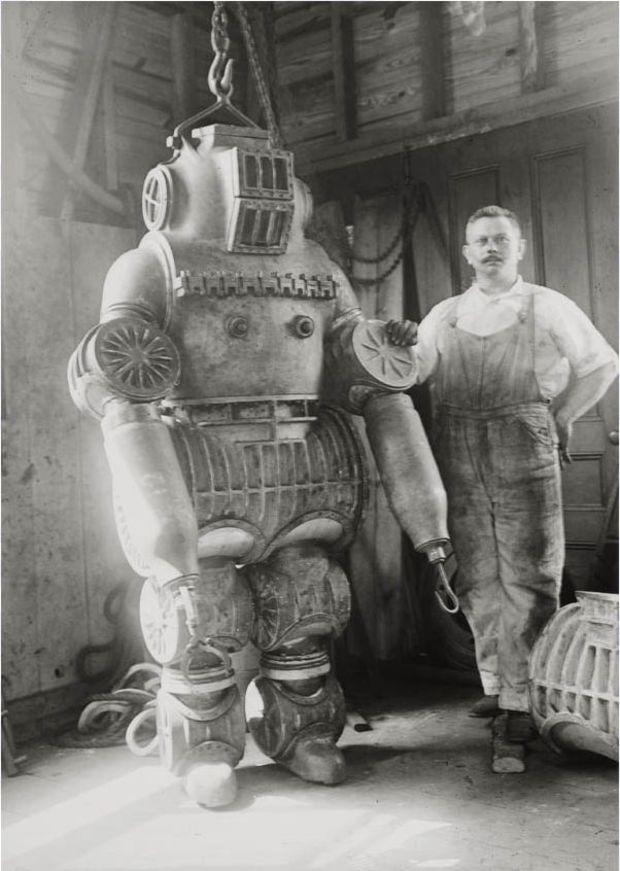 Chester E. Macduffee proudly posing next to his newly patented, 250 kilo diving suit in 1911