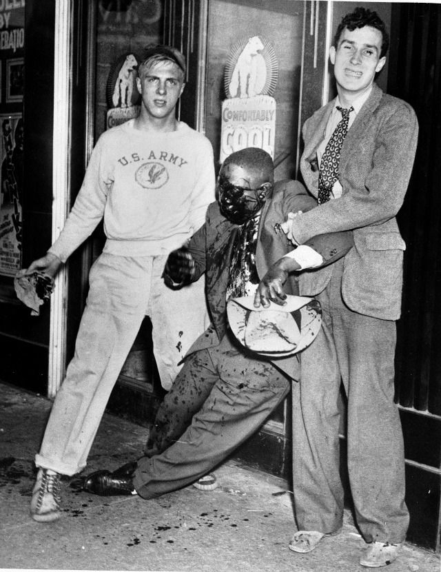 June 20, 1943 White People taking picture with beaten African American