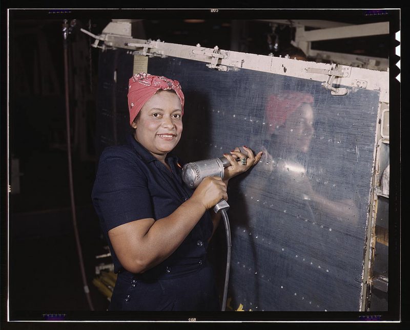 Operating a hand drill at Vultee-Nashville, woman is working on a Vengeance dive bomber, Tennessee