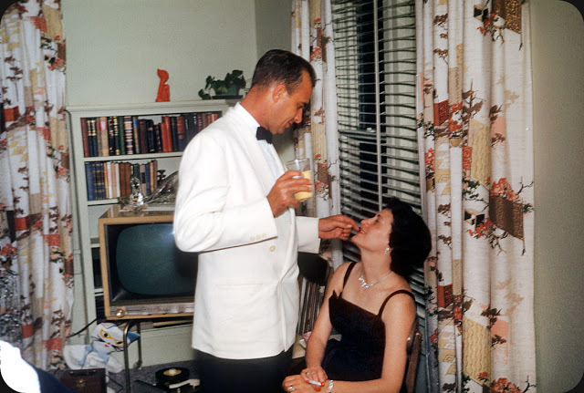 This is how to romance a lady in 1959 with a weird cat-looking thing in the background.