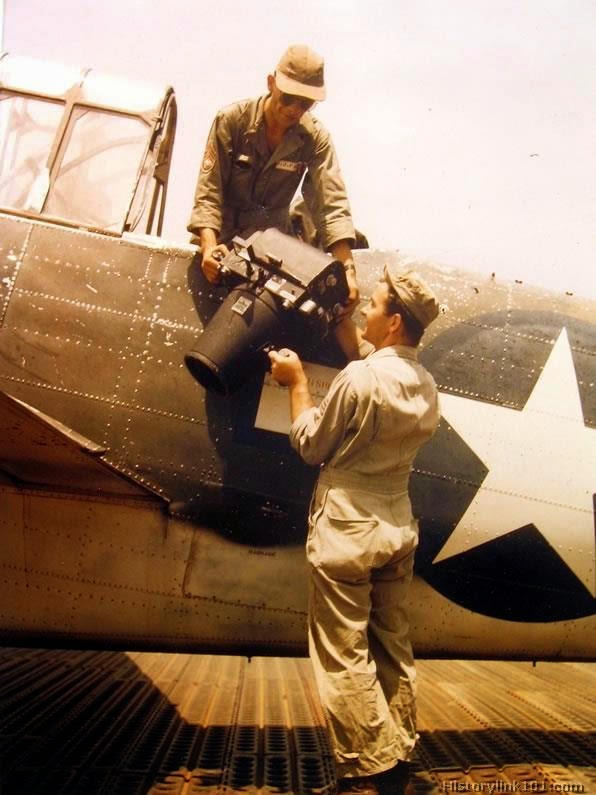 Sgt. handing oblique camera to serial photographer for mission on a North American C-47A.