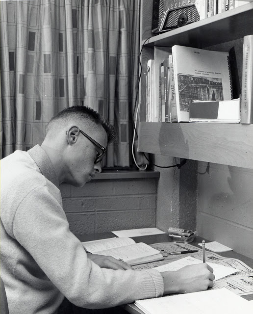 A guy studying in dorm room, ca. 1950s.