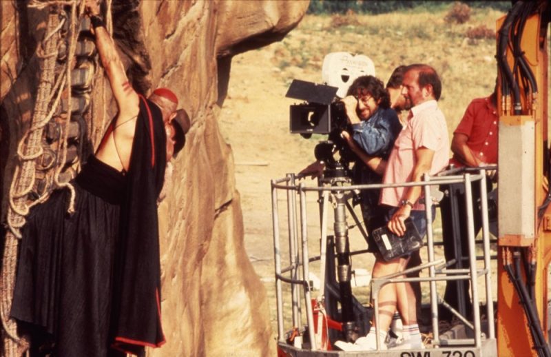On a camera crane, Spielberg films a deadly skirmish on the remains of the rope bridge, hanging down the cliff edge