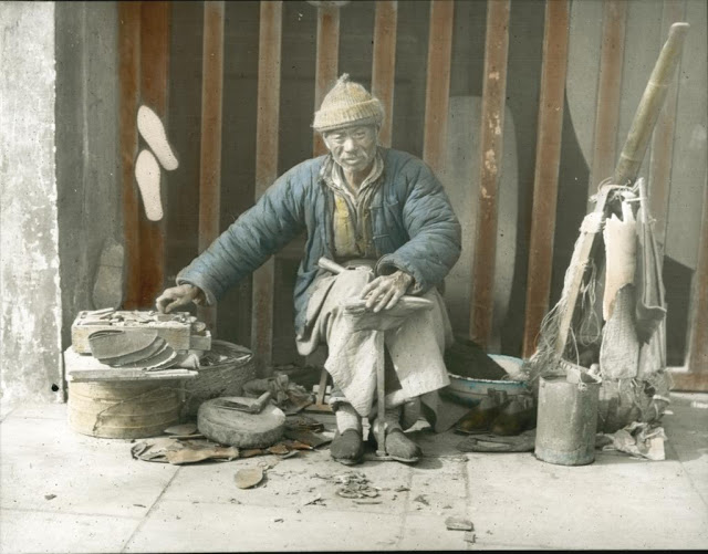 A man in his shoe repair stall