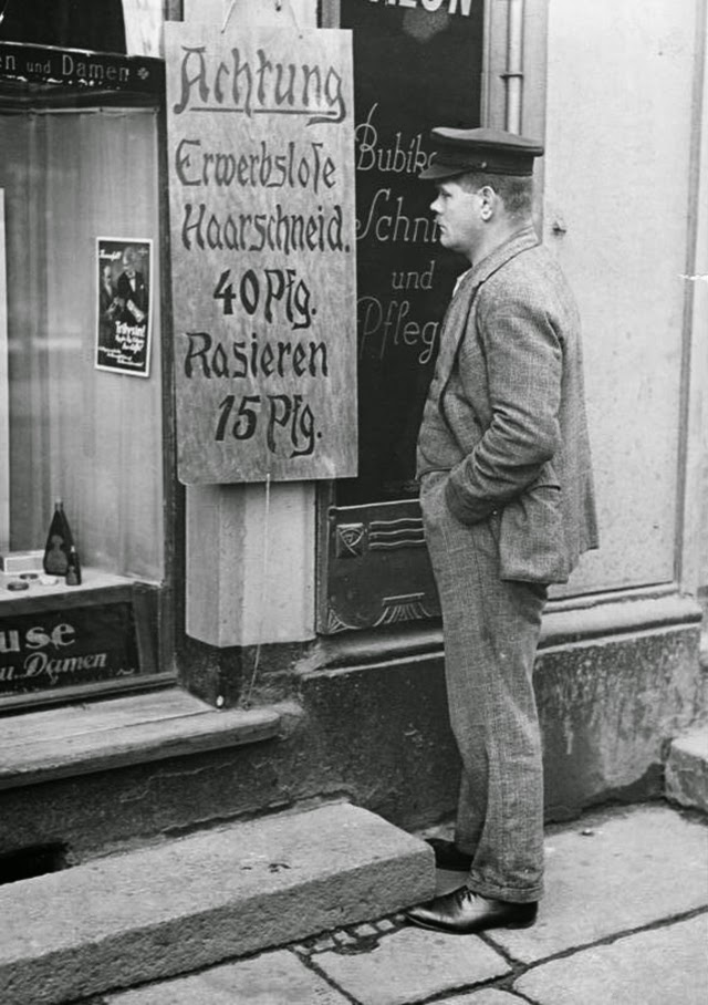 Sign on a barbershop announcing special prices for the unemployed, 1927.