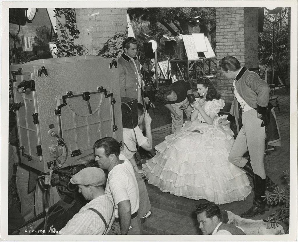 Vivien Leigh touches up her make up as the crew and actors Fred Crane and George Reeves prepare to film the final version of the porch scene.
