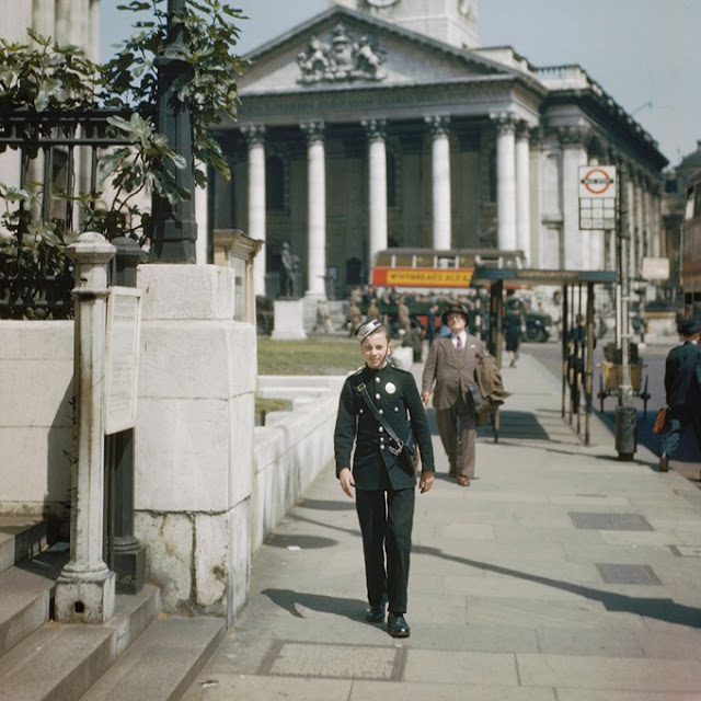 A messenger boy walking past the entrance to the National Gallery in Trafalgar Square London