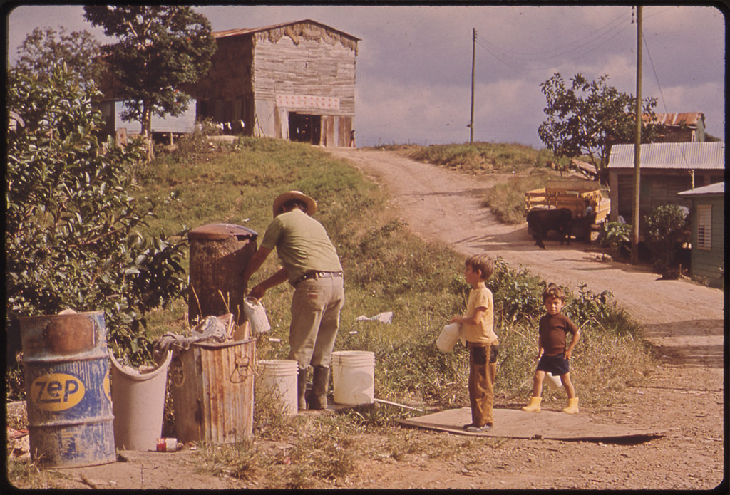 Father and Sons Fill Their Containers at the Community Water-Pump. This Is a Mountain Farming Area.