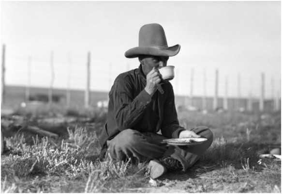 A Cowboy wearing his “ten-gallon“ having a meal during cattle round-up drive. Photo from 1926. Photo credit: Photobucket