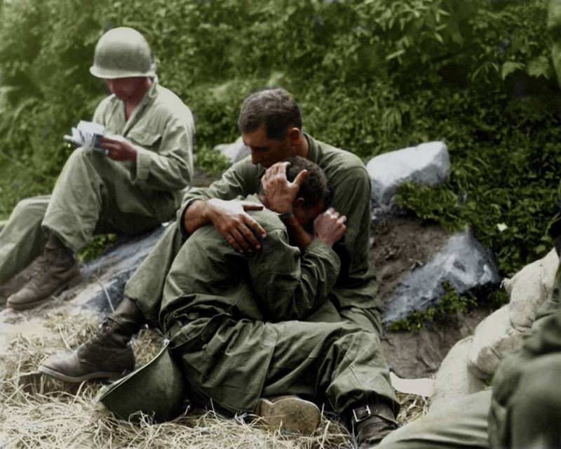 A grief stricken American infantryman whose friend has been killed in action is comforted by another soldier. In the background a corpsman methodically fills out casualty tags, Haktong-ni area, Korea. August 28, 1950. Photographer - Sfc. Al Chang. (Army) (Colorized by Jared Enos from the USA) https://www.facebook.com/JenosColor