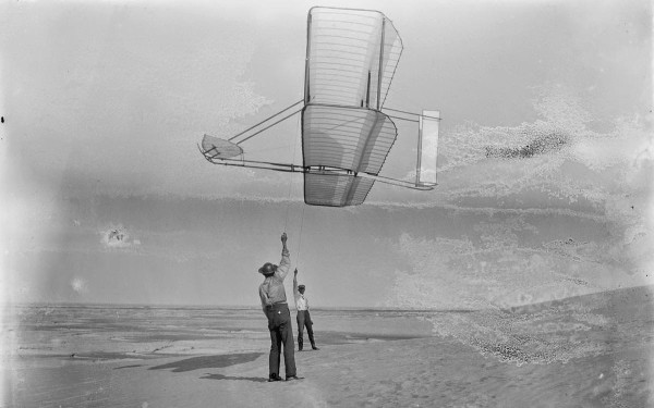Side view of Dan Tate left, and Wilbur Wright, right, flying the 1902 glider as a kite, on September 19, 1902.