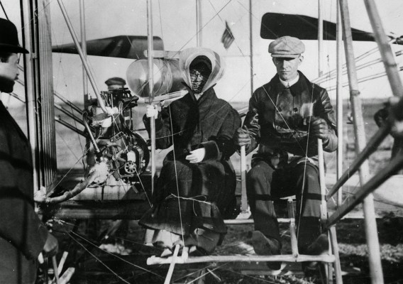 Siblings Orville Wright, Katharine Wright, and Wilbur Wright at Pau, France. Miss Wright about to be taken for her first ride in an airplane. February 15, 1909.