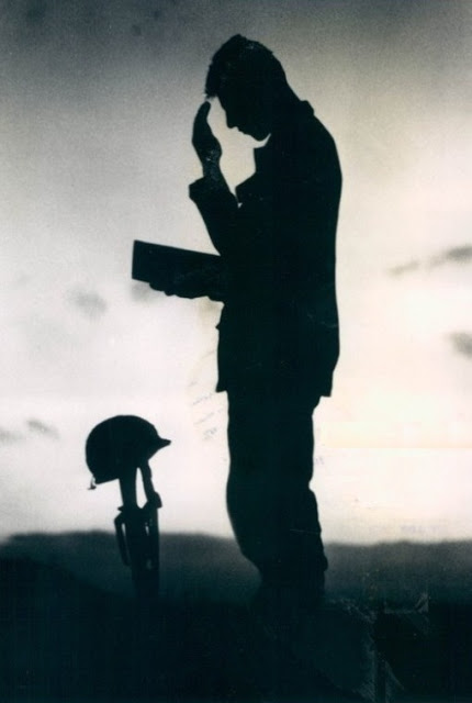 An unidentified U.S. soldier takes a moment to pray for the fallen men on this Memorial Day in Vietnam, May 30, 1968