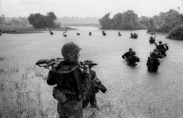 Paratroopers cross a river in the rain near Ben Cat, South Vietnam, 1965
