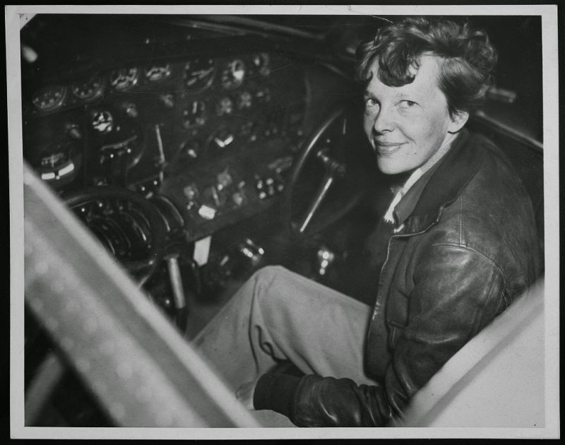 Amelia Earhart sitting in the cockpit of an Electra airplane, 1937
