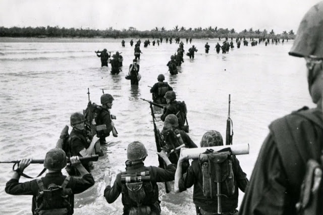 U.S. Marines from amphibious force ships off Vietnam wade ashore to converge on a Viet Cong position, 9 September 1966