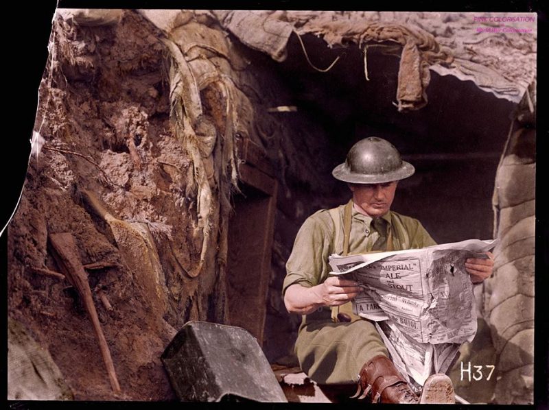 A New Zealand Officer sits at the entrance of a dug-out in the Front Line, reading a newspaper. Near Messines, Belgium May 15 1917. (Photo source - National Library of New Zealand Photographer - Henry Armytage Sanders. (Colorised by Benoit Vienne from France) https://www.facebook.com/World-War-Colorisation-790508287736232/?fref=nf