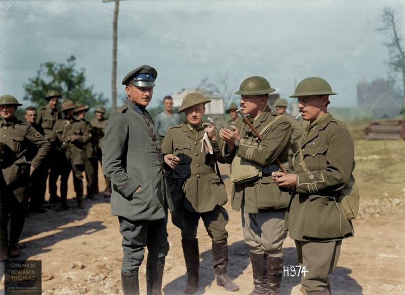 The German medical officer, Lt Schnelling of the 14th Bavarian Regiment, who was detailed to attend to the German wounded and who came to a 3rd New Zealand Field Ambulance station near the front line. Schnelling, left, is pictured with Colonel J. Hardie Neil and Major H. M. Goldstein, M.C. Photograph taken near Bapaume, France, 27 August 1918. "...... the dressing station was pushed up to Achiet-le-Petit, and 500 casualties were passed through. Here three German medical officers presented themselves. One was the A.D.M.S. of a Naval Division; another, one of his staff; the third, Lt. Schnelling, of the 14th Bavarian Regiment. It transpired that this last was the medical officer who had been in charge of that cellar in Flers in which such ample personal correspondence, supplies, surgical instruments and medical comforts were found, these coming into Major Goldstein's possession at that time......" (24th August 1918) (Achiet-le-Petit is about 6kms from Bapaume) (Colourised by Benjamin Thomas from Australia)