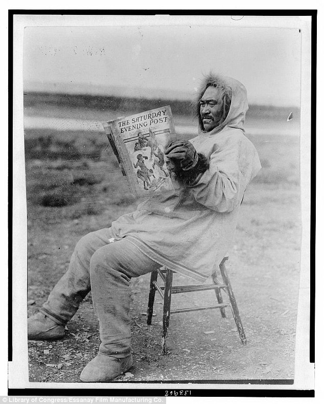 A man sits back in a frozen field while reading a copy of the Saturday Evening Post in 1913