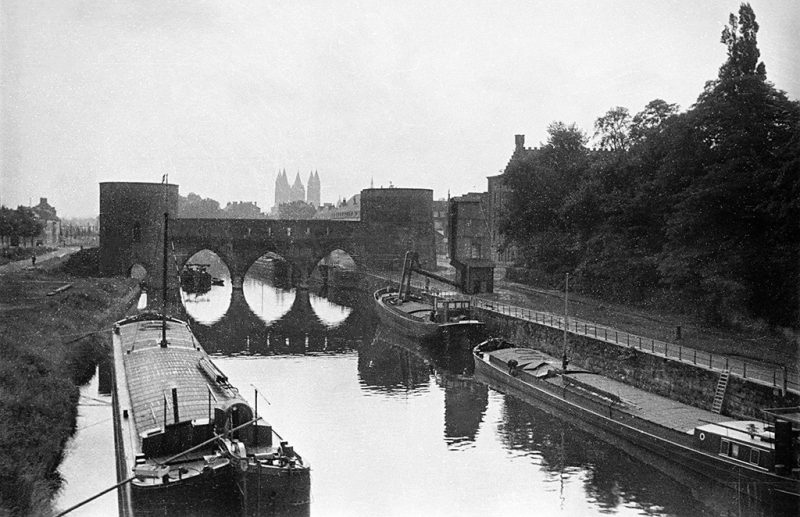 The medieval bridge _Pont des Trous_ (_bridge of holes_) and barges in the river Schelde (L'Escaut) in Tournai