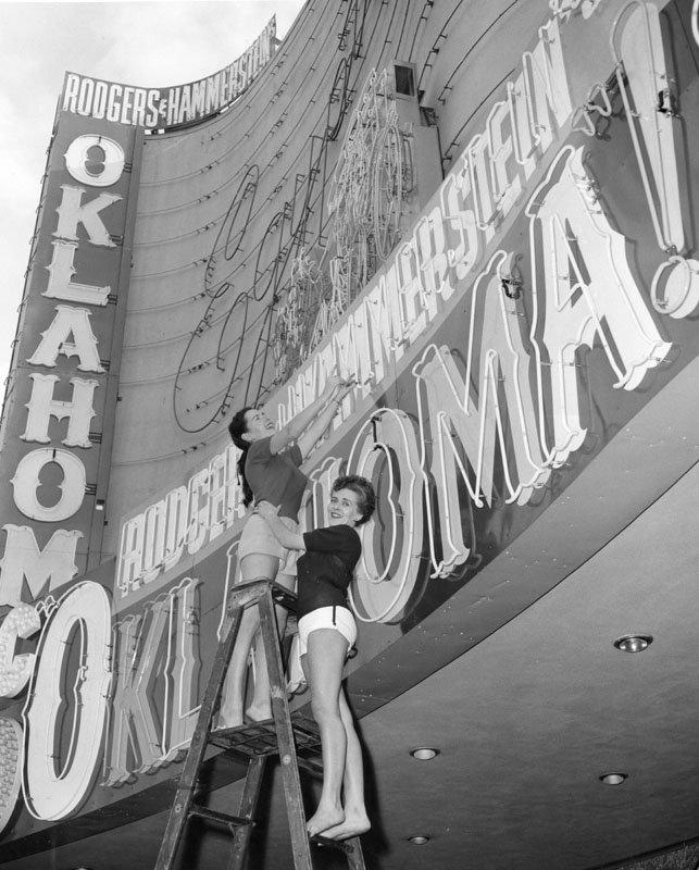 Two women on a ladder by the marquee of the Egyptian Theatre