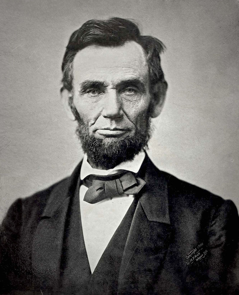 An iconic black and white photograph of a bearded Abraham Lincoln showing his head and shoulders.source