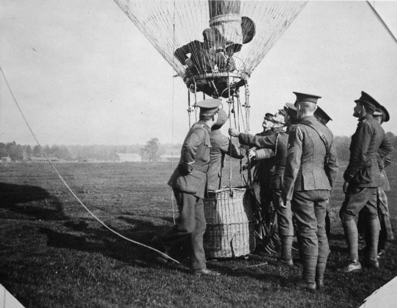 An observation balloon basket with a group of soldiers stood around it another soldier appears to be working on the rigging above the basket. Aviation in Britain Before the First World War. source:Wikipedia/Public Domain