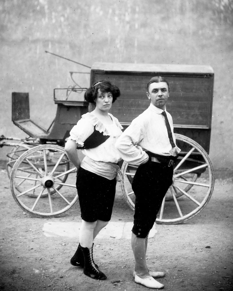 Circus performers pose in front of a wagon. c.1910