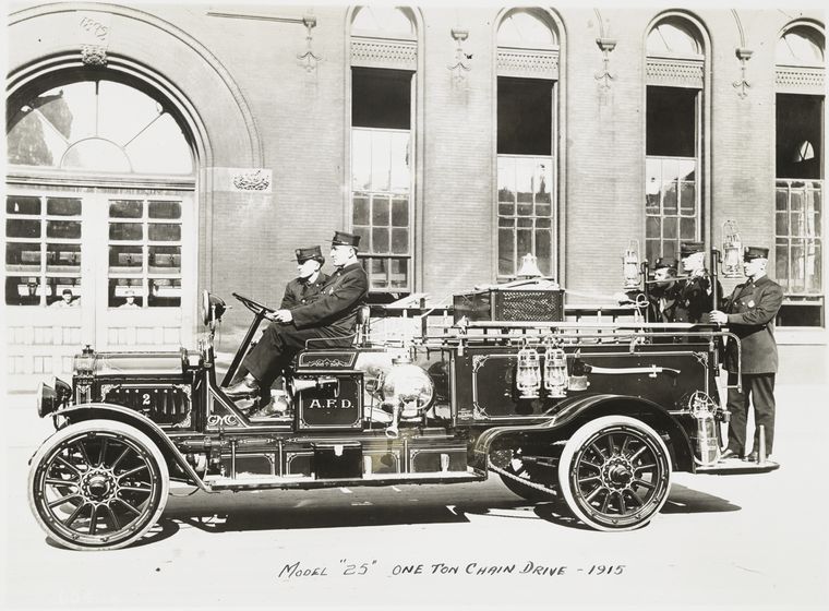 Model 25 One ton chain drive – 1915. [Fire truck carrying uniformed fire fighters]