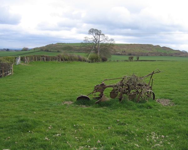 Old Oswestry Hillfort Viewed from the footpath between Pentre-clawdd and the road past Old Oswestry, the Iron Age hillfort is still an amazing structure after 3,000 years. In the foreground the old plough is slowly rusting away.Source