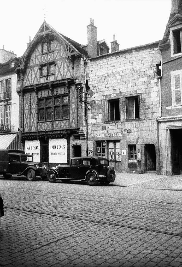 Place Bossuet in Dijon. Cars parked in front of a half-timbered house, Hôtel Catin de Richemont from the 15th century, with the bakery Mulot & Petitjean, and to the right a grocery