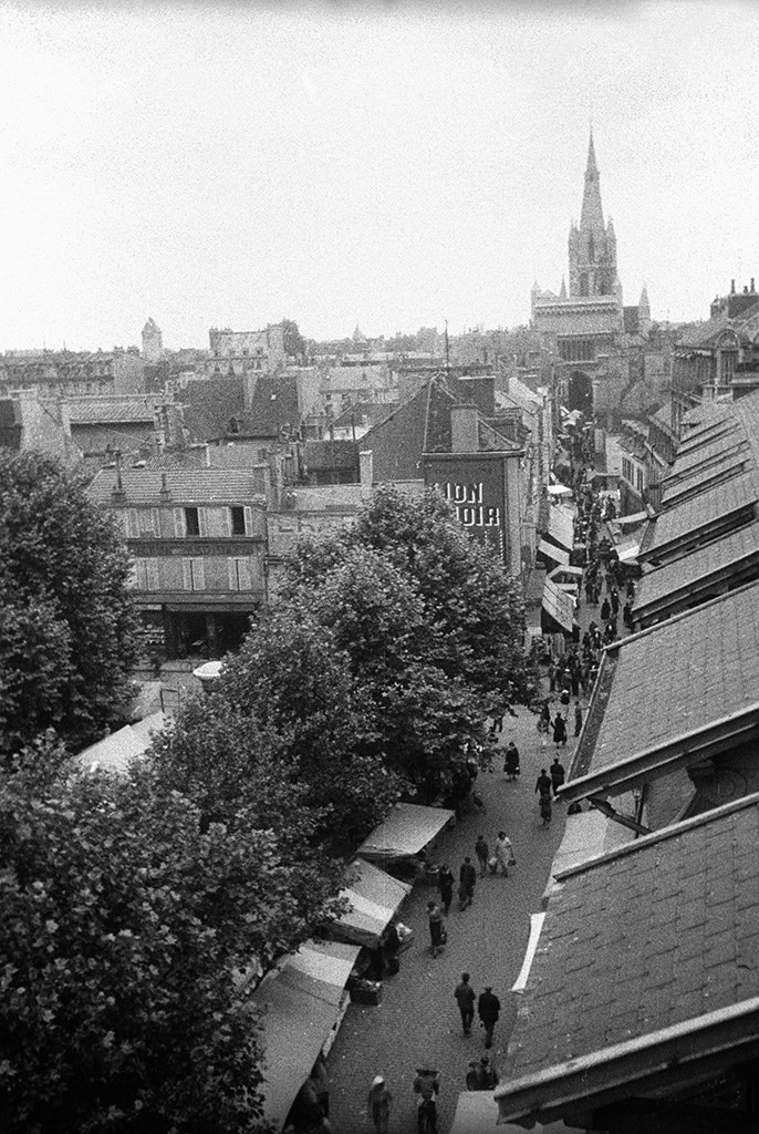 The street Rue Musette in Dijon. Market stalls at Place Grangier in the foreground, and the church Notre-Dame de Dijon at the end of the street