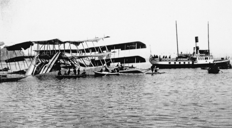 The wreck of the Transaereo is towed to shore after the accident, on March 4, 1921. The boat may be the same that interfered with the aircraft’s takeoff, possibly causing it to crash. source