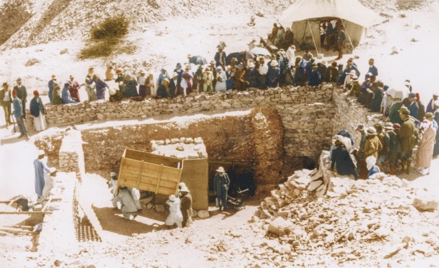 Tourists crowd around the entrance to the tomb to watch a large object, possibly a couch from the Antechamber, being removed from Tutankhamun's tomb, on its way to the workroom.