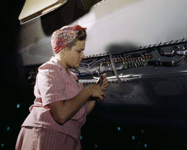 A Douglas Aircraft Company employee does delicate electrical work on a plane at the plant in Long Beach, California.