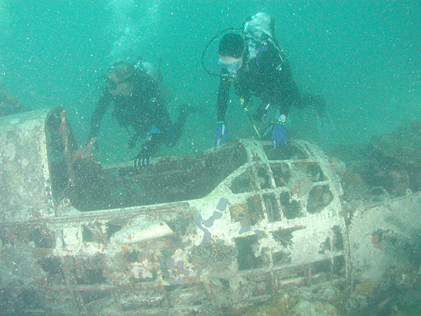 Divers next to cockpit of Aichi E13 Jake floatplane wreck, Kavieng harbor, New Ireland. Papua New Guinea. Source