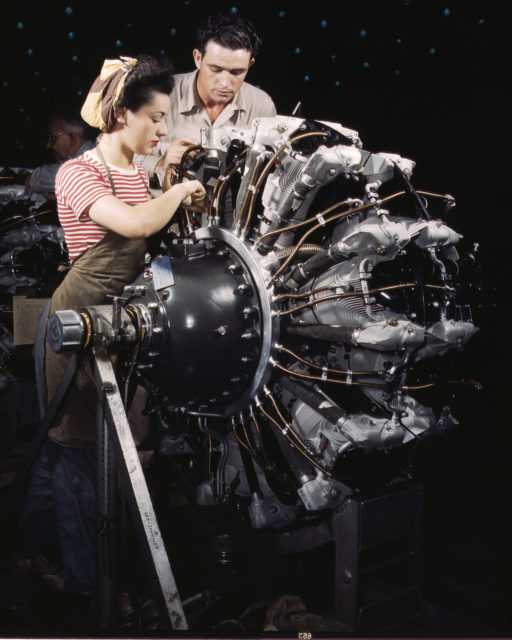 Douglas Aircraft Company employees work on an airplane motor at the plant in Long Beach, California.