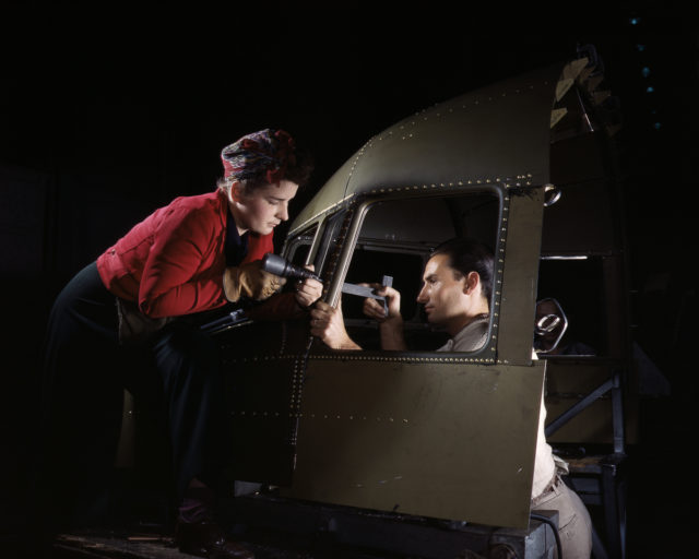 Riveters work on the cockpit shell of a B-25 bomber at the North American Aviation Company plant in Inglewood, California.