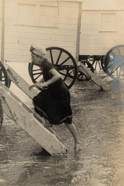 Another woman uses a bathing machine. She also has her hair in a scarf. 1906