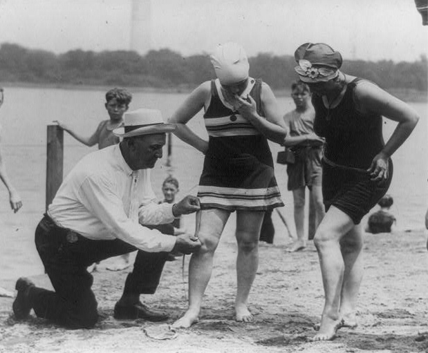 Bill Norton the bathing beach policeman measuring distance between knee and bathing suit on woman, Washington, D.C.