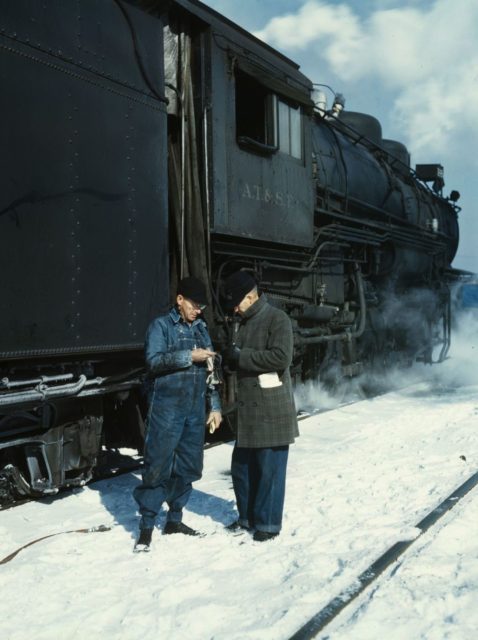 Conductor George E. Burton and engineer J.W. Edwards compare time before pulling out of the Corwith railroad yard.